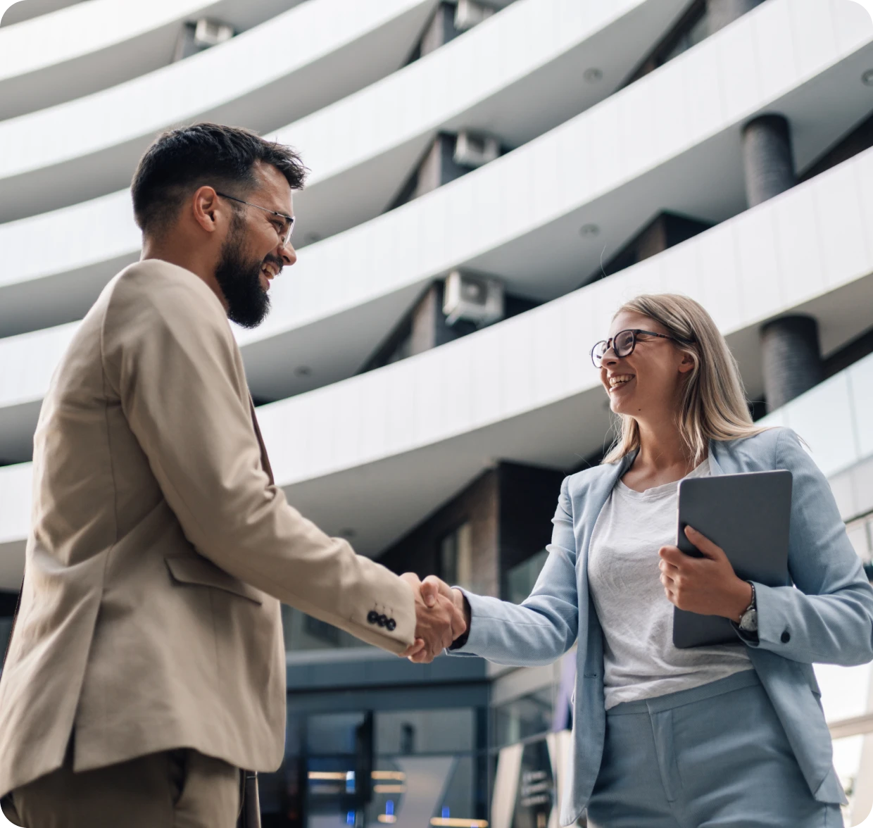 Businesspeople shaking hands in modern building.