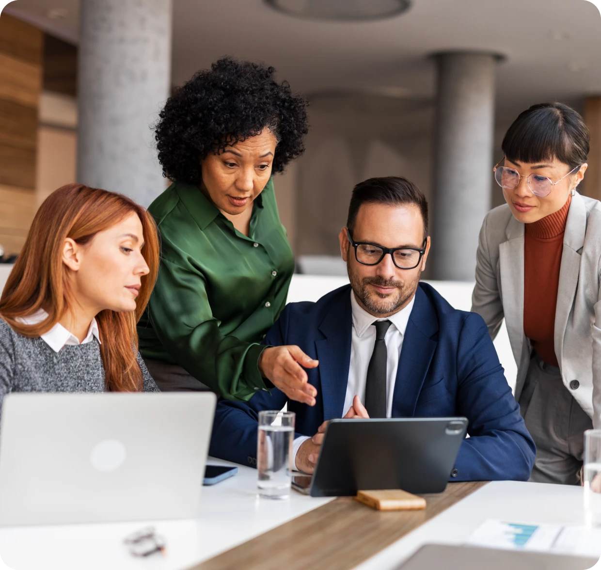 Business team collaborating around a tablet.