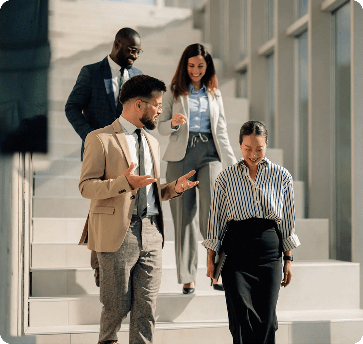 Four professionals walking down office stairs.